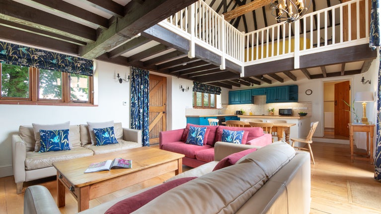 The open-plan kitchen, dining and sitting room at 3 Horsey Barns, with gallery above and vaulted ceiling, Norfolk